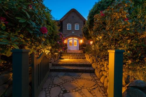 a house with a gate and stairs leading to a door at Hotel Parkresidenz Christian VIII in Archsum