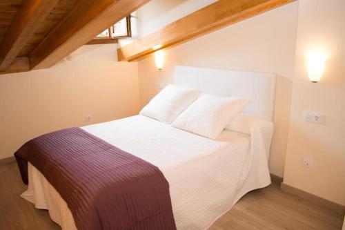 a bedroom with a white bed in a room at APARTAMENTOS RURALES El Llagar de Cue in Llanes