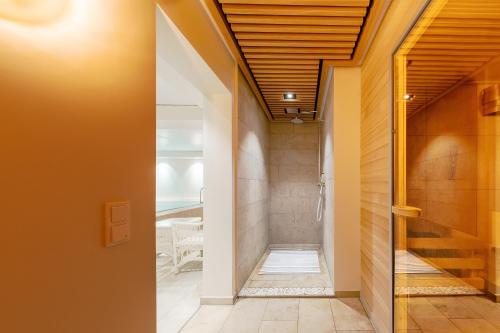 a hallway with orange walls and wooden ceilings at Hotel Parkresidenz Christian VIII in Archsum