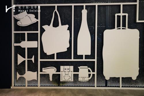 a room with a shelf with clothing and a suitcase at Hotel Initial-Taichung in Taichung