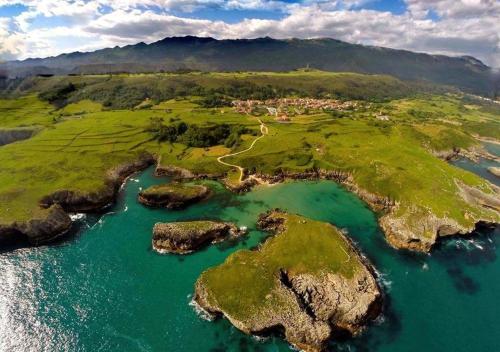 an island in the ocean with rocks in the water at APARTAMENTOS RURALES El Llagar de Cue in Llanes
