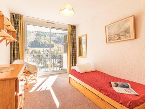 a hotel room with a bed and a balcony at Appartement lumineux 2 pièces, 6 couchages, proche pistes et commerces, avec parking et balcon - FR-1-330F-114 in Serre Chevalier
