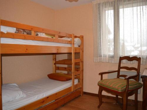 a bedroom with two bunk beds and a chair at Appartement Le Grand-Bornand, 5 pièces, 8 personnes - FR-1-241-197 in Le Grand-Bornand