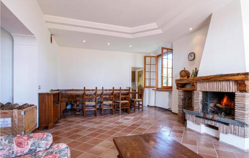 a living room with a fireplace and a dining room at Gorgeous Home In V, Di Montecopiolo in Pugliano