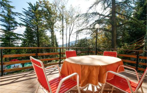 a table and chairs on a deck with trees at Gorgeous Home In V, Di Montecopiolo in Pugliano