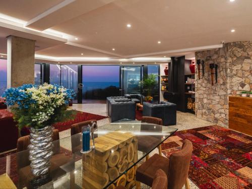 a living room with a glass table and a fireplace at Boutique Ocean Views - incorporating Wendy's in Hermanus