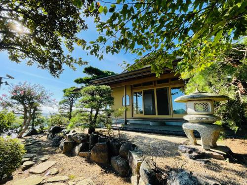 einen Garten mit einer Steinlaterne vor einem Gebäude in der Unterkunft Hitachinaka Villa DAN - ひたちなか 暖 - in Hitachinaka