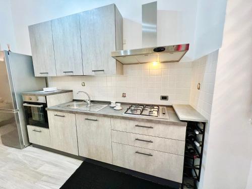a kitchen with white cabinets and a stove top oven at da Mumminedda in Cinisi