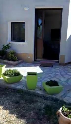 a patio with two green containers in front of a house at Camera Tina in Castellammare del Golfo