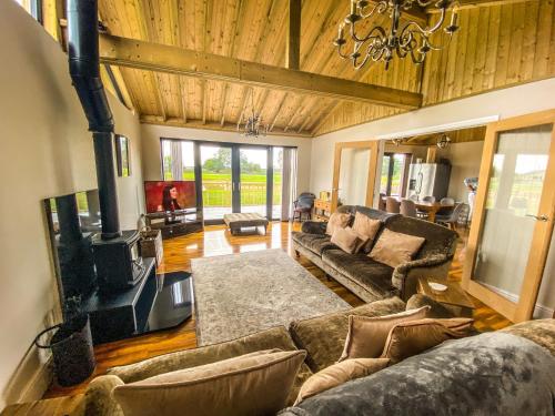 un ampio soggiorno con divani e TV di Immaculate 4-Bed Private Luxury Lodge near York a York