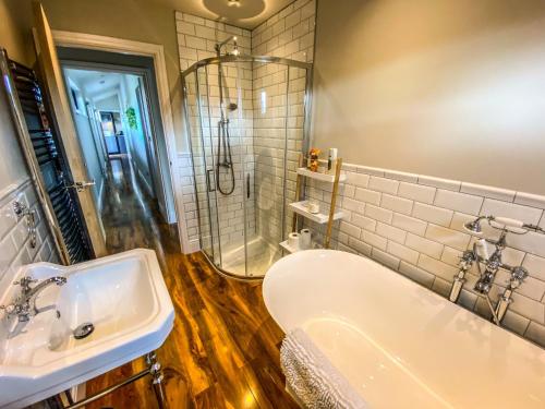 uma casa de banho com uma banheira, um lavatório e um chuveiro em Immaculate 4-Bed Private Luxury Lodge near York em York