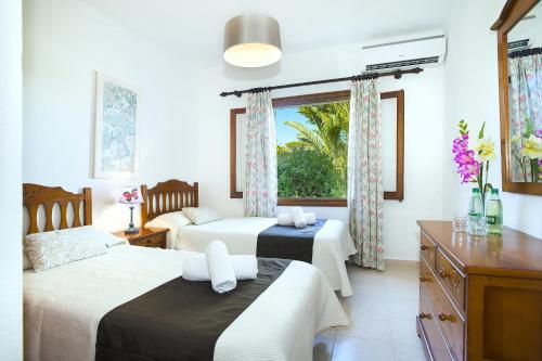 El Port的住宿－Pollensa - 40788 Mallorca，一间卧室设有两张床和窗户。