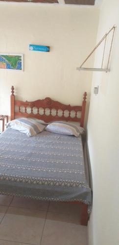 a bed with a wooden headboard in a room at Suíte externa com entrada independente in São Sebastião