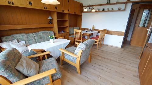 een woonkamer met een tafel en stoelen bij MONA aus KMB Seeappartement direkt am Ossiacher See mit Hallenbad Terasse Skiarena Gerlitzen in Bodensdorf