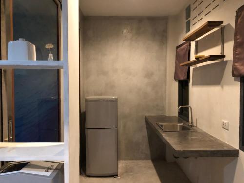 eine kleine Küche mit Spüle und Kühlschrank in der Unterkunft Beach Way Apartment in Koh Samui 
