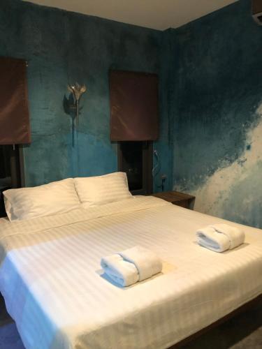 una camera da letto con un grande letto bianco con asciugamani di Beach Way Apartment a Ko Samui