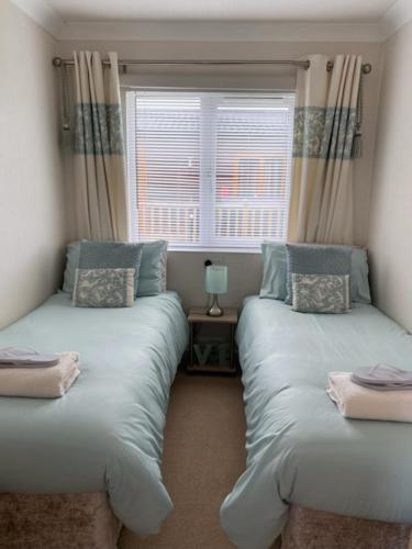 two beds in a room with a window at Hermanas retreat in Felton