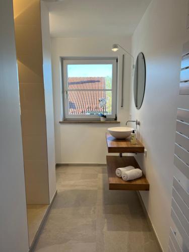 a bathroom with a sink and a window at Wanderlust Chiemgau in Bad Endorf