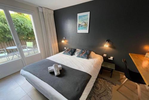 a bedroom with a bed with a cross on it at Le Clos Du Pontic Logis et Cit'Hotel in Landerneau