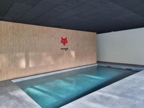 una piscina con una estrella roja en la pared en Zonga Chalet Catan, en Waulsort