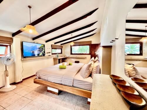 a bedroom with a bed and a flat screen tv at Three rare & private front beach villas in Thongsala