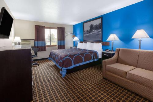 a hotel room with a bed and a couch at Super 8 by Wyndham Elkhart in Elkhart