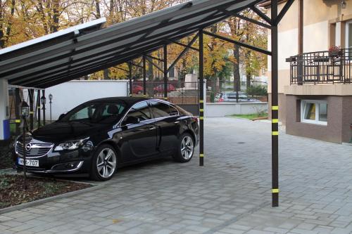 a black car parked under a parking lot at Lévay Villa Hotel in Miskolc