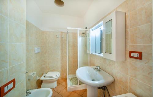 a bathroom with a white sink and a toilet at 1 Bedroom Beautiful Apartment In Isola Rossa in Isola Rossa