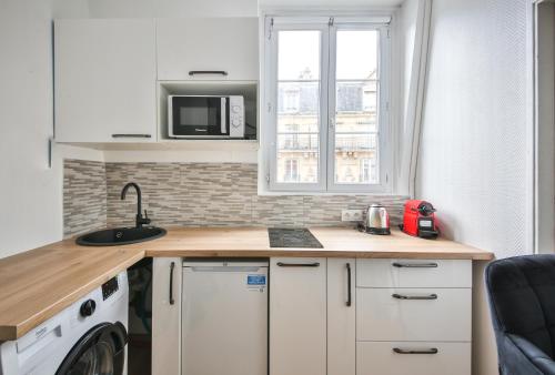 kuchnia z blatem z pralką i suszarką w obiekcie 43#Studio 2Pers#Sèvres-Lecourbe#Necker w Paryżu