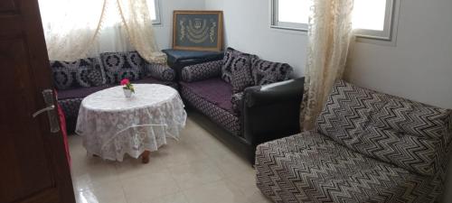 uma sala de estar com um sofá e uma mesa em Dar Ba Brahim em Rabat