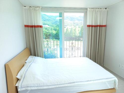 a bedroom with a bed and a large window at Gamseong House in Sejong