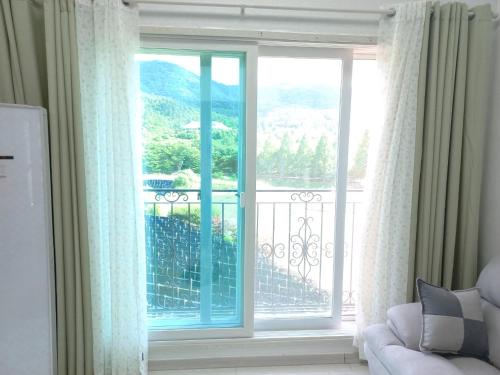 a room with a large window with a view of a balcony at Gamseong House in Sejong
