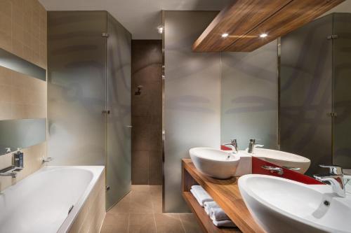 a bathroom with two sinks and a shower at Mamaison Hotel Riverside Prague in Prague