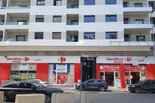 a store with cars parked in front of a building at A 200m de la Plage, du Haut Standing au coeur du Parc in Mohammedia