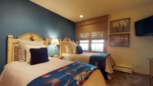 a bedroom with two beds and a flat screen tv at Montaneros in Vail in Vail