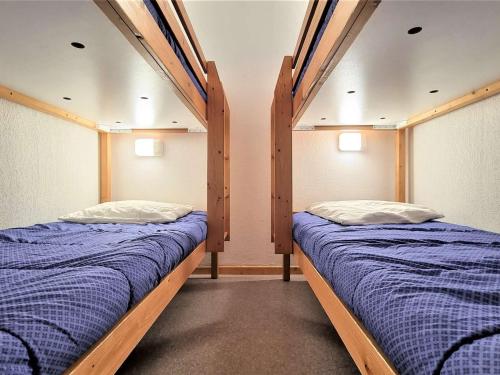 Ce dortoir comprend 2 lits superposés et des draps bleus. dans l'établissement Appartement 8 pers avec balcon, proche commerces et pistes, casier à ski - FR-1-525-199, à Saint-Étienne-en-Dévoluy