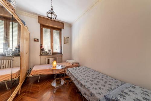 Cette chambre comprend 2 lits jumeaux et une table. dans l'établissement Appartamento con Ampia Terrazza - 10 minuti da Torino, à Moncalieri