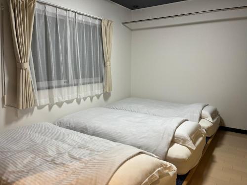 2 camas en una habitación con ventana en ＡkＢ63 en Sapporo