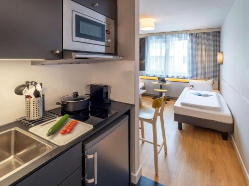 a small kitchen with a sink and a counter top at Aparthotel Adagio Access Freiburg in Freiburg im Breisgau