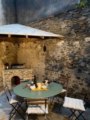 une table et des chaises devant un mur de pierre dans l'établissement La petite maison de Savennières, à Savennières