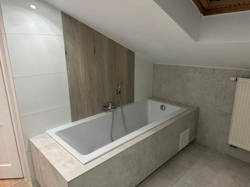 een groot wit bad in de badkamer bij Apartament Nidzica Rzemieślnicza 4 in Nidzica