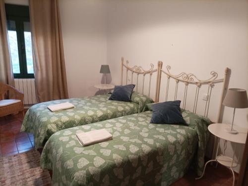 Dos camas en una habitación de hotel con toallas. en El Huerto de Pipo, en Navarredonda de Gredos