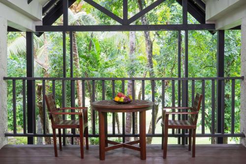 a table with two chairs and a bowl of fruit on a balcony at Wyndham Hua Hin Pranburi Resort & Villas in Ban Pak Nam Pran