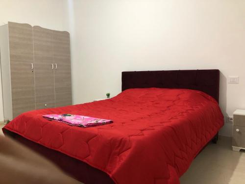 a bedroom with a red bed with a red blanket at Maison Karam in Rabat