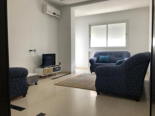 - un salon avec deux chaises et une télévision dans l'établissement Maison Karam, à Rabat