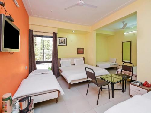 pokój hotelowy z dwoma łóżkami i telewizorem w obiekcie Hotel Shree w mieście Indore