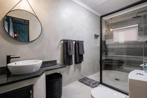 ein Bad mit einem Waschbecken und einem Spiegel in der Unterkunft Mukumbura Lodge Bilene in Vila Praia Do Bilene