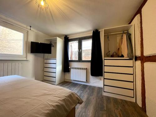 ein Schlafzimmer mit einem Bett, einer Kommode und einem Fenster in der Unterkunft L'Alsacien - Appartement avec Terrasse - Cuisine équipée - WiFi Gratuit in Sélestat