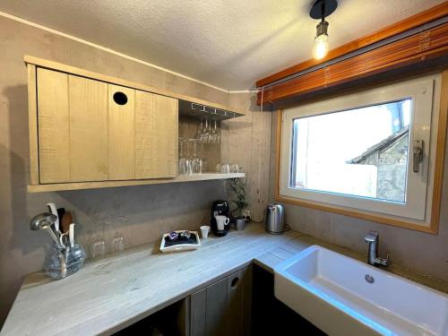 eine Küche mit Spüle und Fenster in der Unterkunft L'Alsacien - Appartement avec Terrasse - Cuisine équipée - WiFi Gratuit in Sélestat