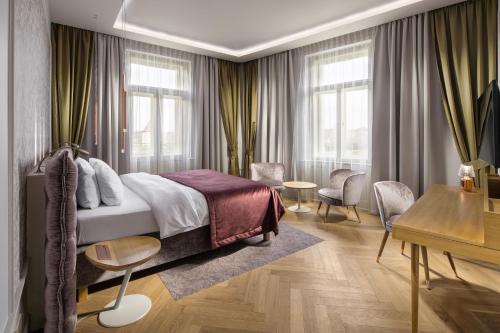 プラハにあるマメゾン ホテル リバーサイド プラハのベッドルーム1室(ベッド1台、デスク、窓付)